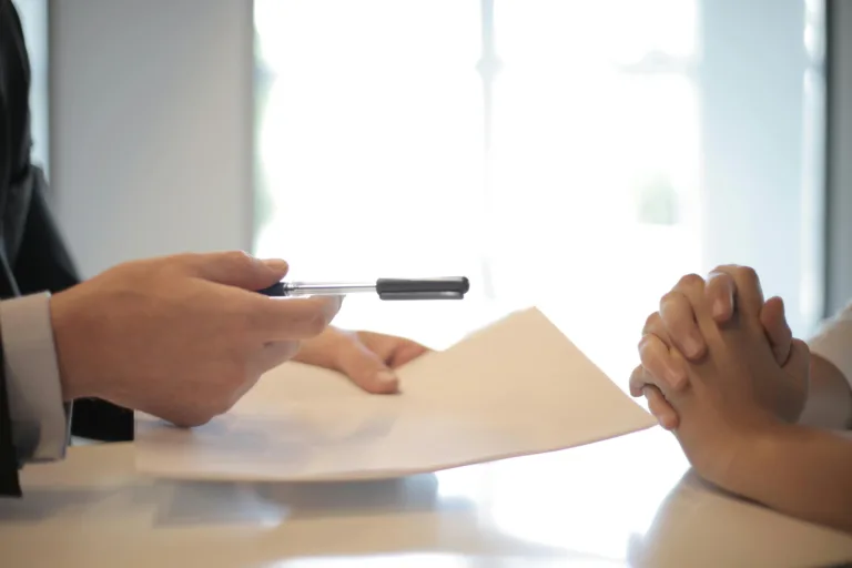 Person holding paper and pen during professional meeting